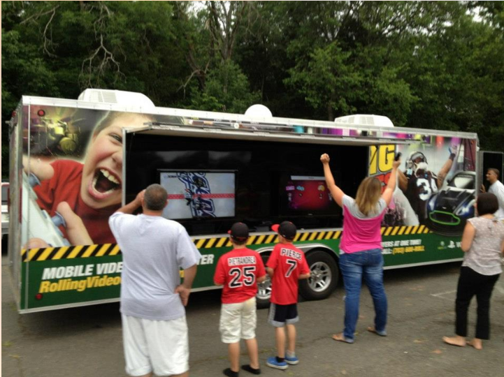 Photograph of the gaming truck with people around it